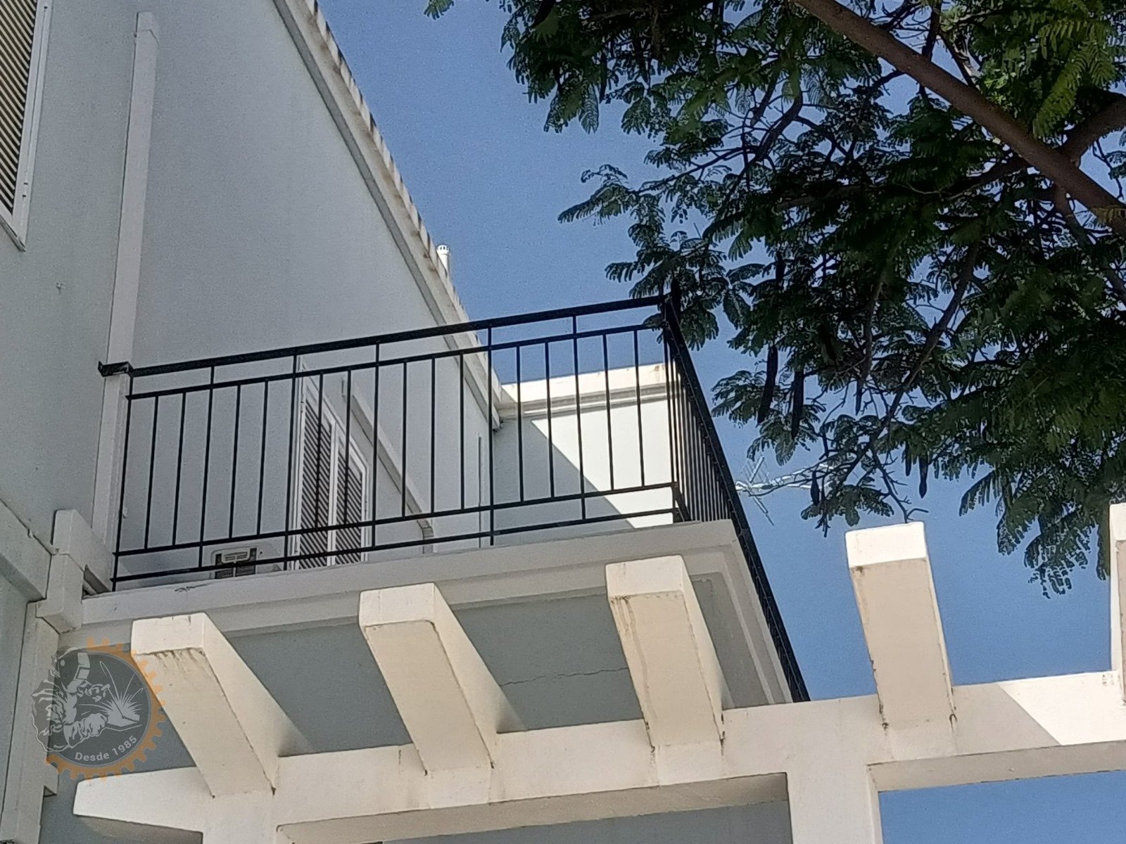 Baranda negra de barrotes verticales en un balcón