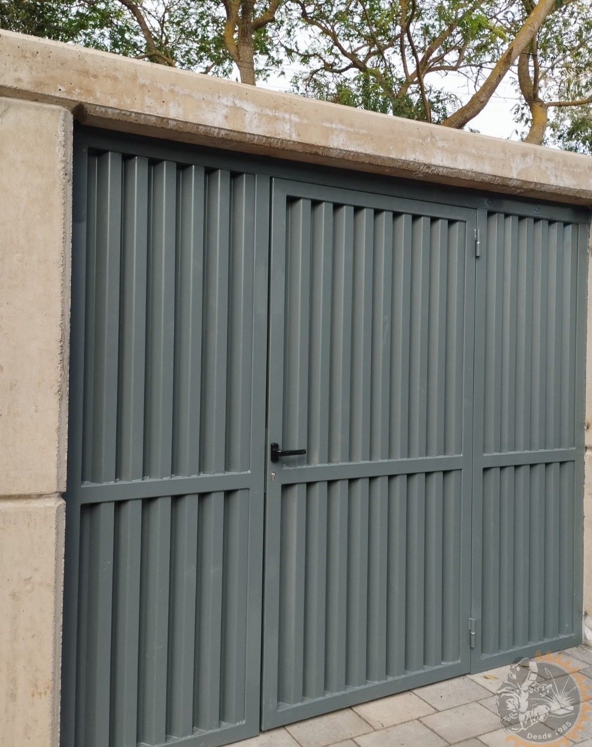 Cancela gris de lamas verticales con puerta peatonal integrada