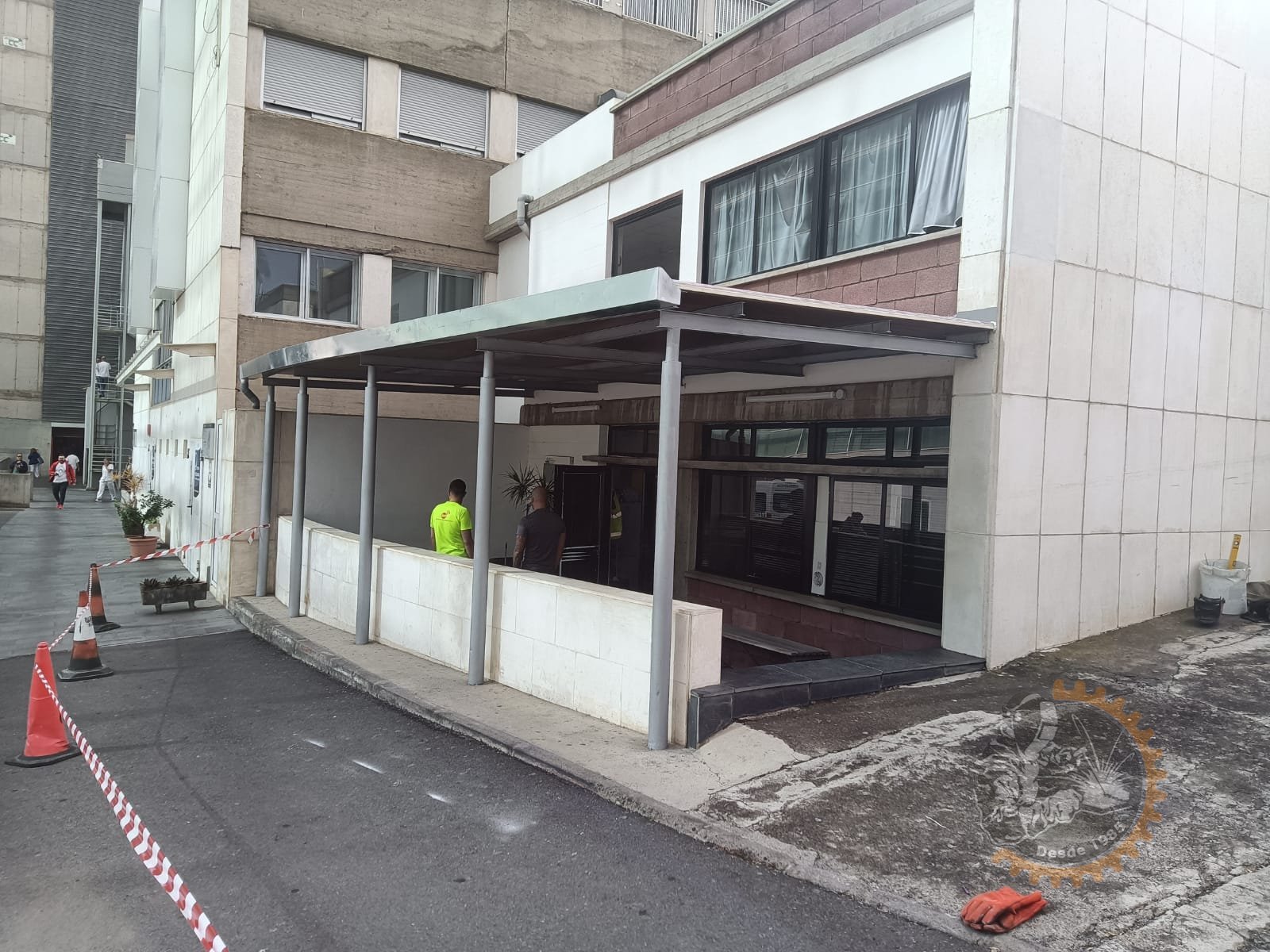 Marquesina de pilares y vigas metálicas junto a la fachada de un edificio