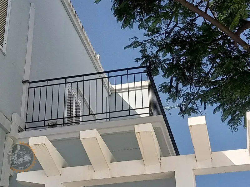 Baranda negra de barrotes verticales en un balcón