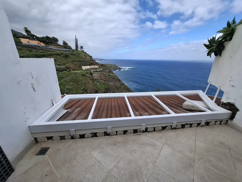 Bastidor rectangular blanco sin rejilla instalado entre los muros de una terraza