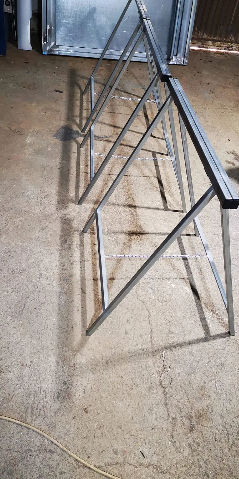 Caballetes de perfiles metálicos con patas en forma de A y cadenas entre apoyos