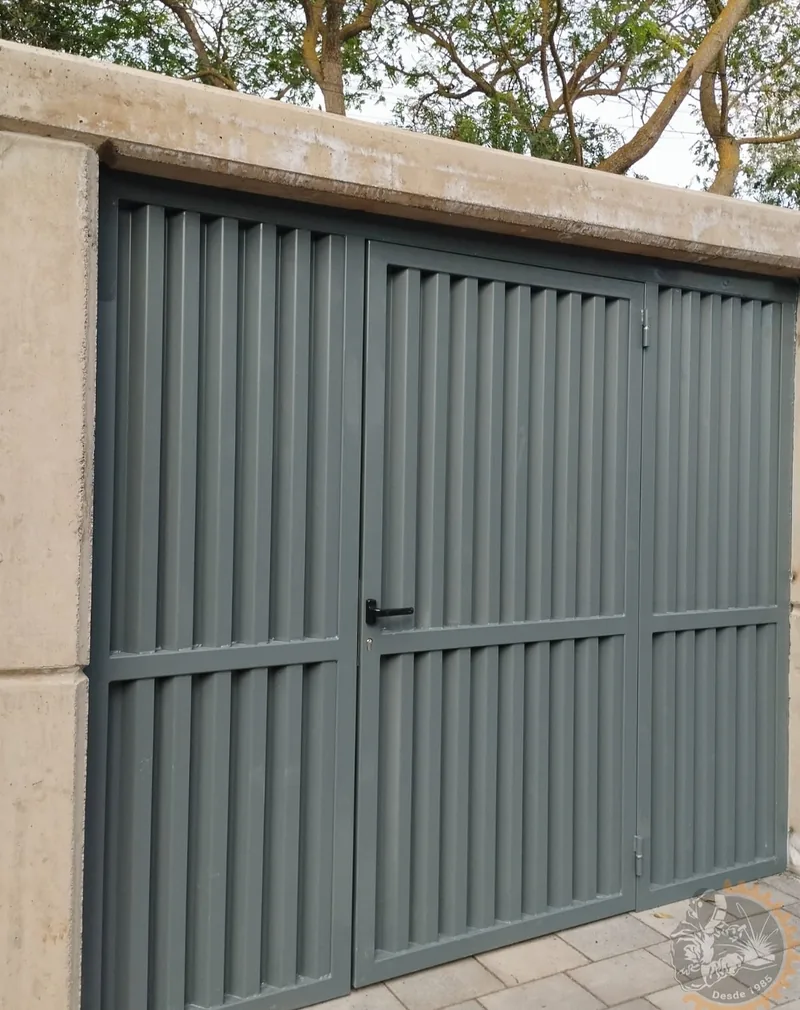 Cancela gris de lamas verticales con puerta peatonal integrada