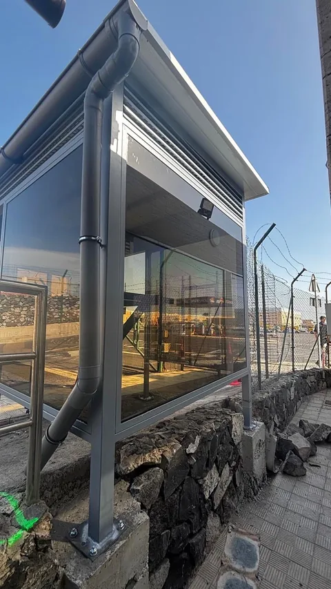 Lateral del cerramiento con canalón, bajante y bases de pilares metálicos