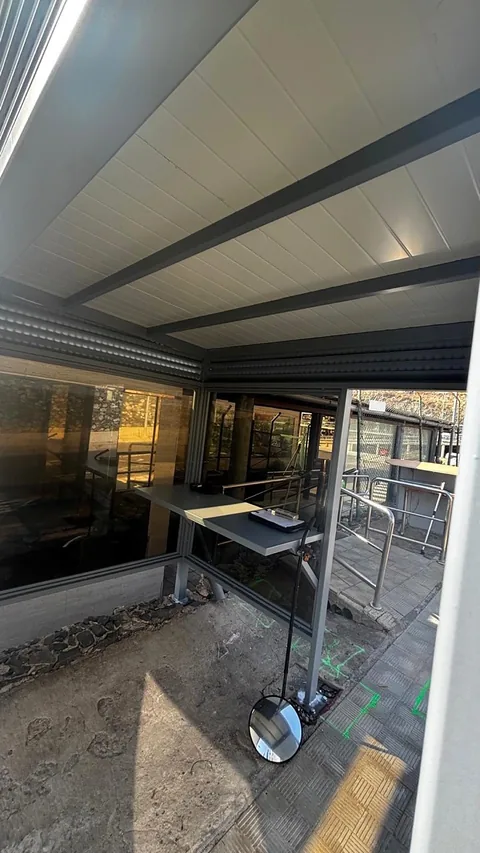 Interior del cerramiento con perfiles metálicos bajo la cubierta blanca