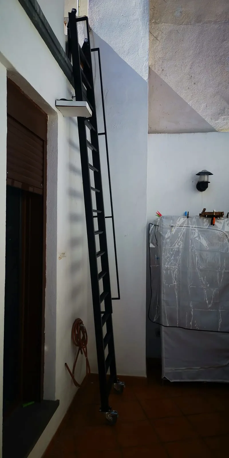 La misma escalera negra más próxima a la pared exterior
