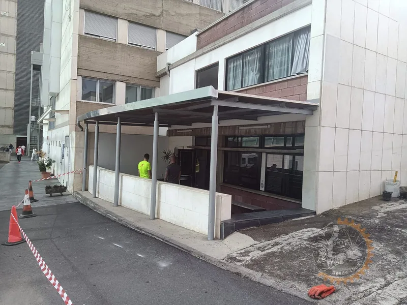 Marquesina de pilares y vigas metálicas junto a la fachada de un edificio