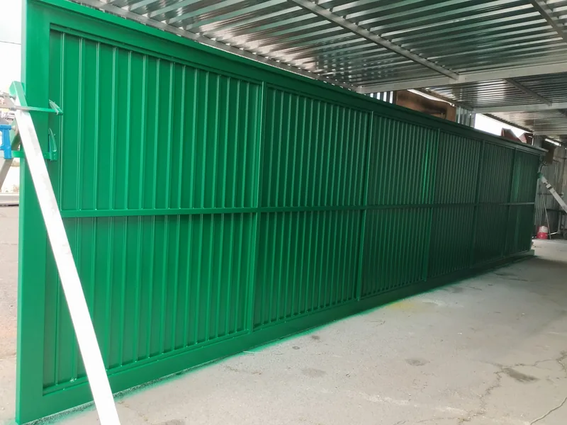 Cara posterior de un portón verde con bastidor rectangular y travesaño horizontal durante el montaje